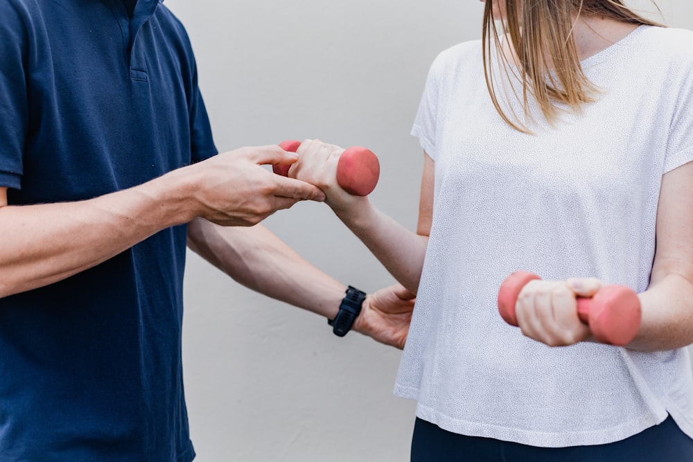 a man and a woman holding dumbs in their hands