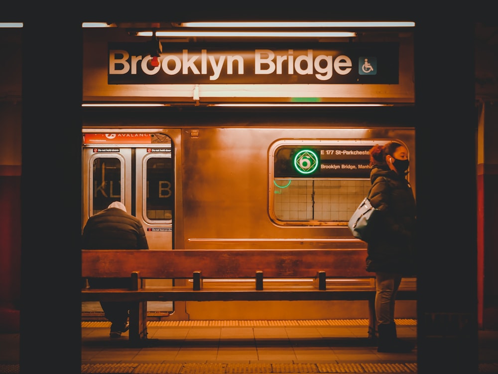 two people waiting for a subway train at the station