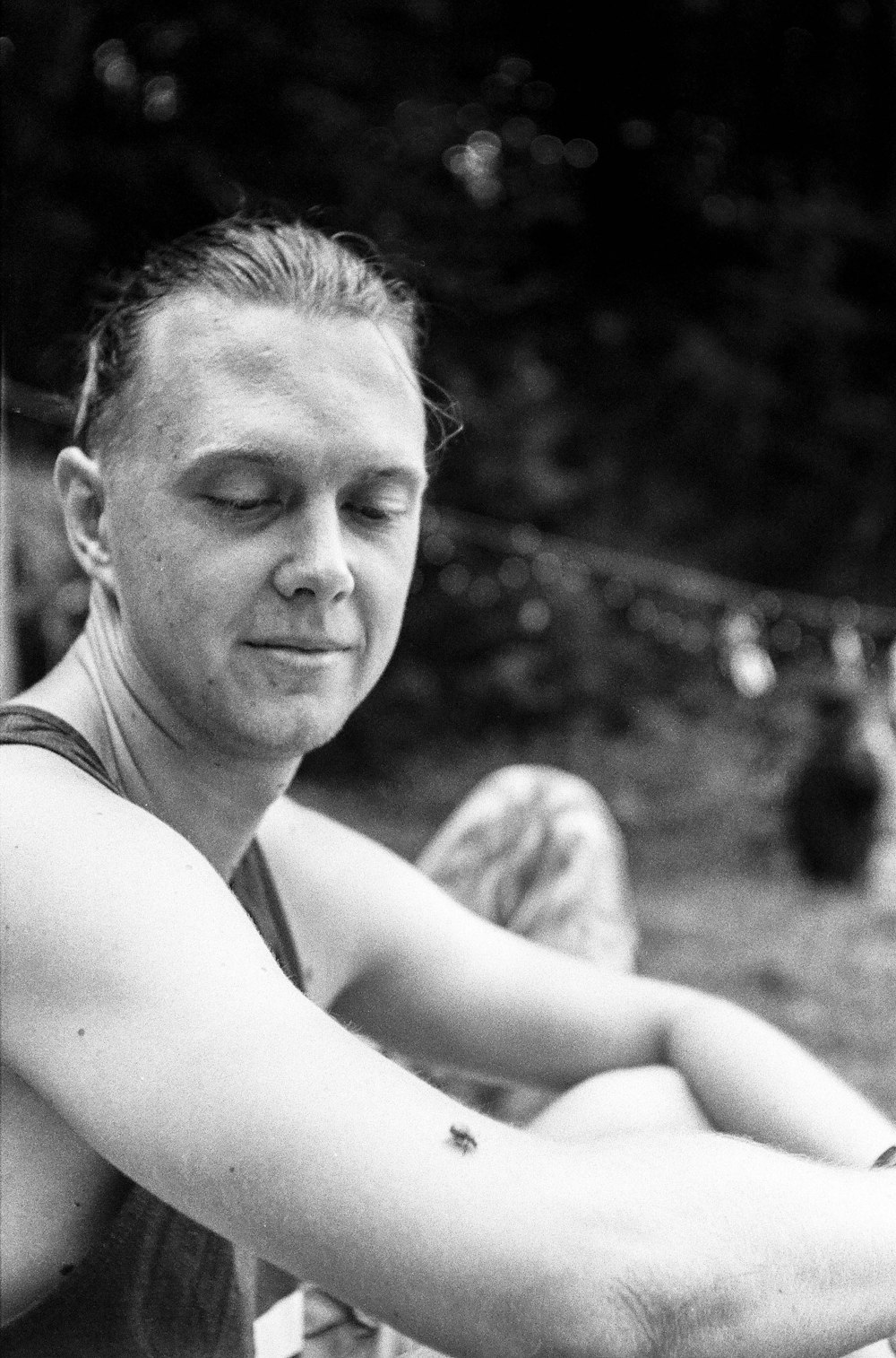 a black and white photo of a man sitting on a bench