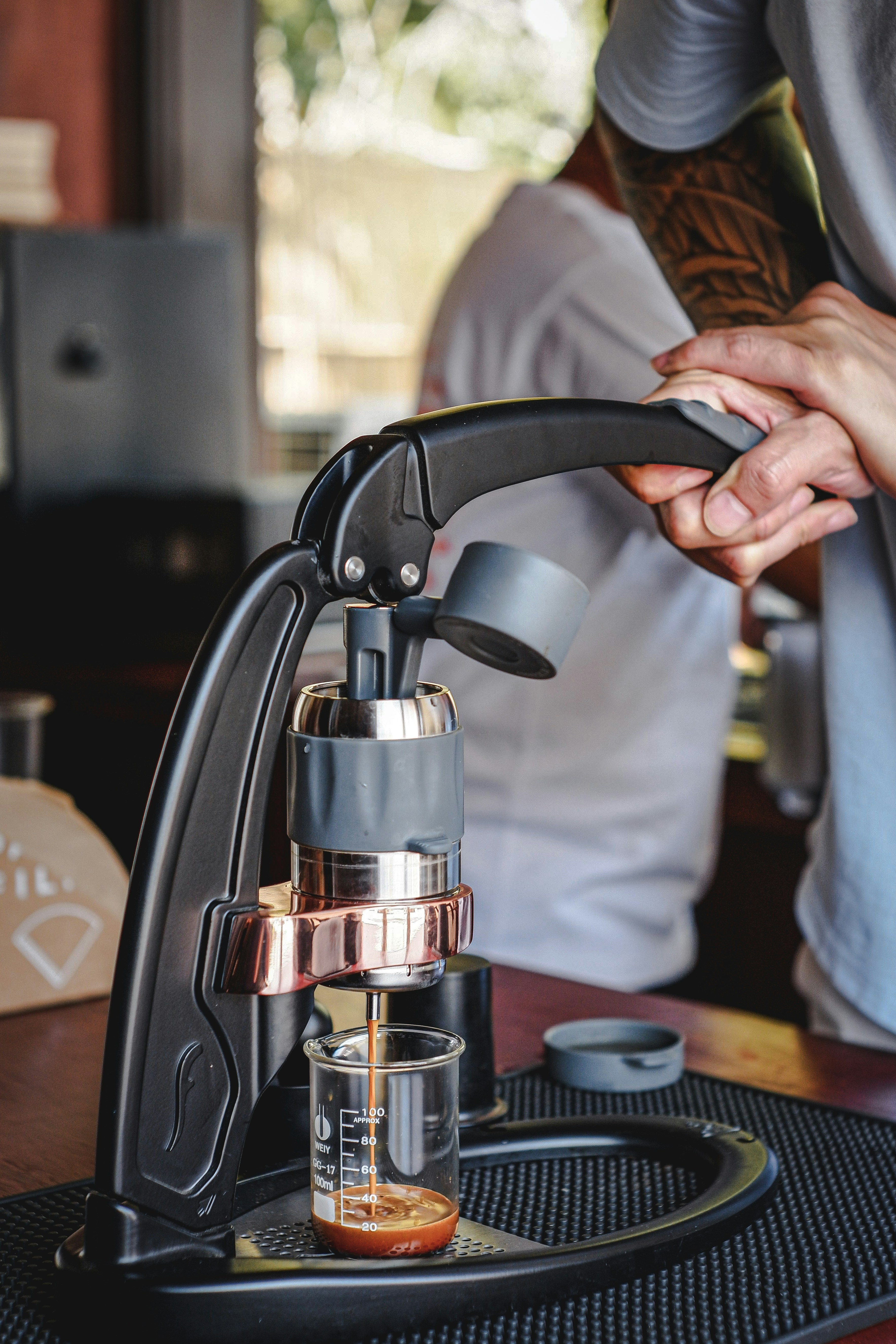 a person standing over a coffee maker on a table