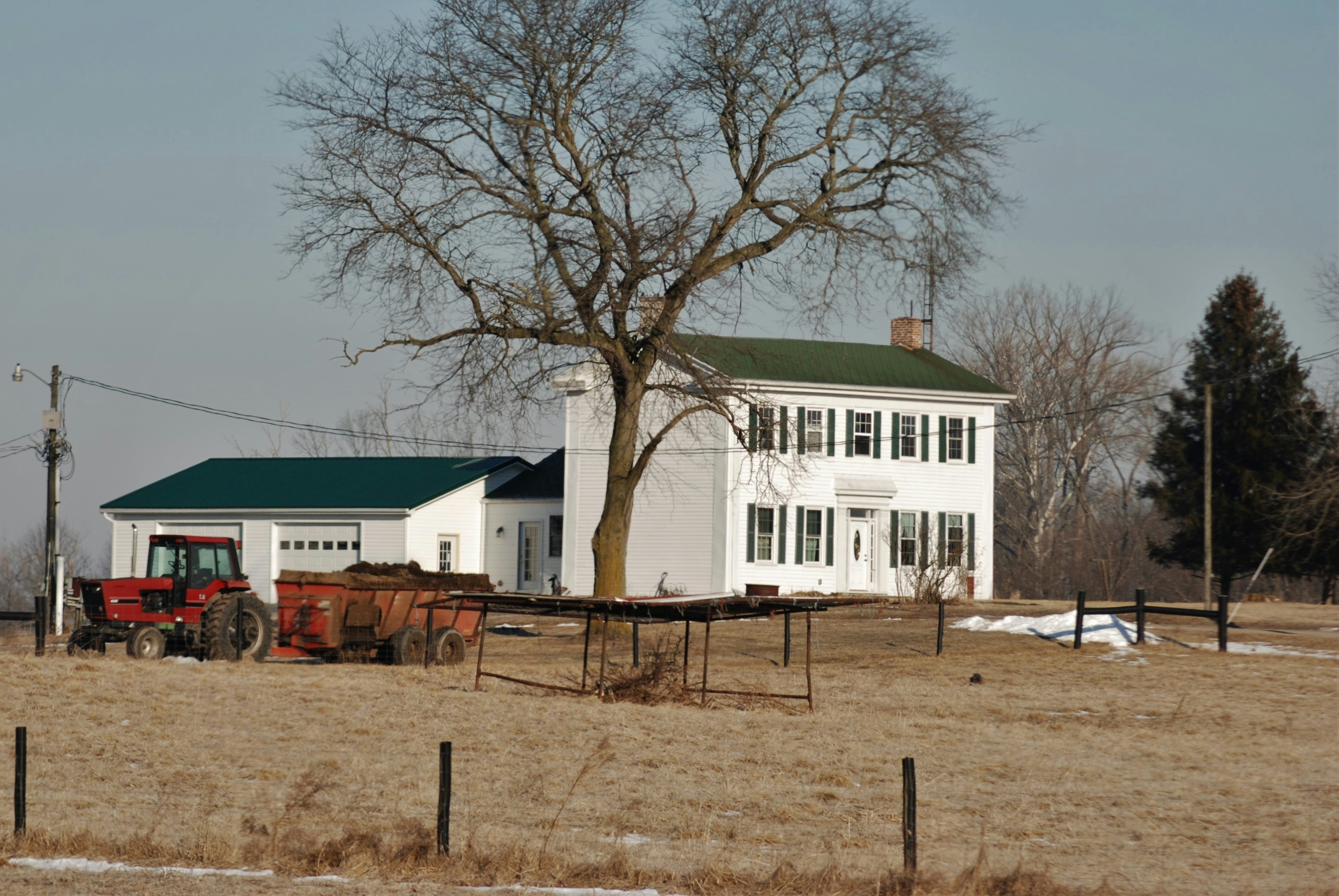 White brick farmhouse with tractor