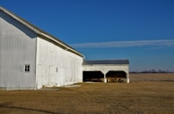 a large white barn with a solar panel on the roof