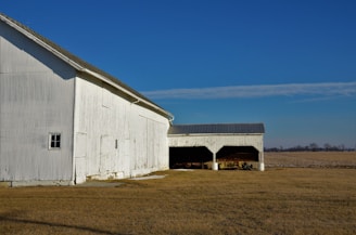 a large white barn with a solar panel on the roof