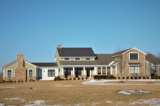 a large house with a lot of windows and a lot of snow on the ground