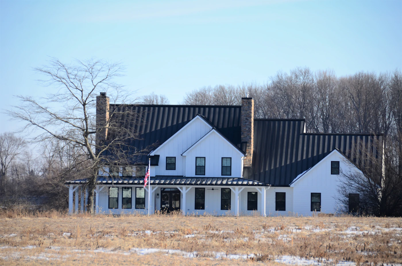 White modern farmhouse exterior with black roof and black window frames