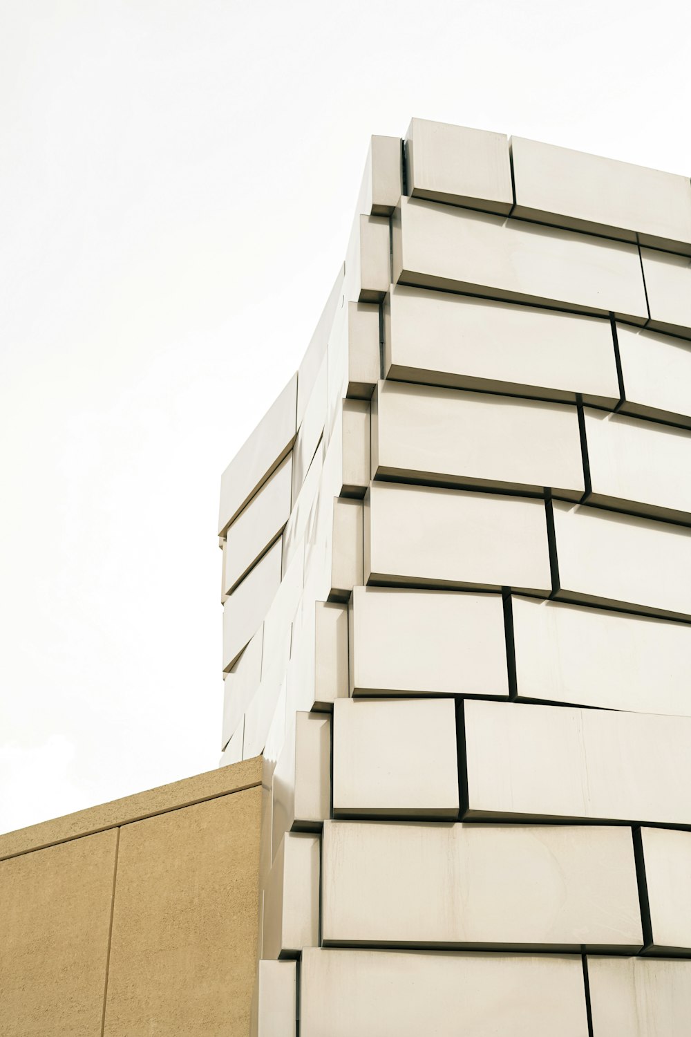 a tall white building sitting next to a tall building