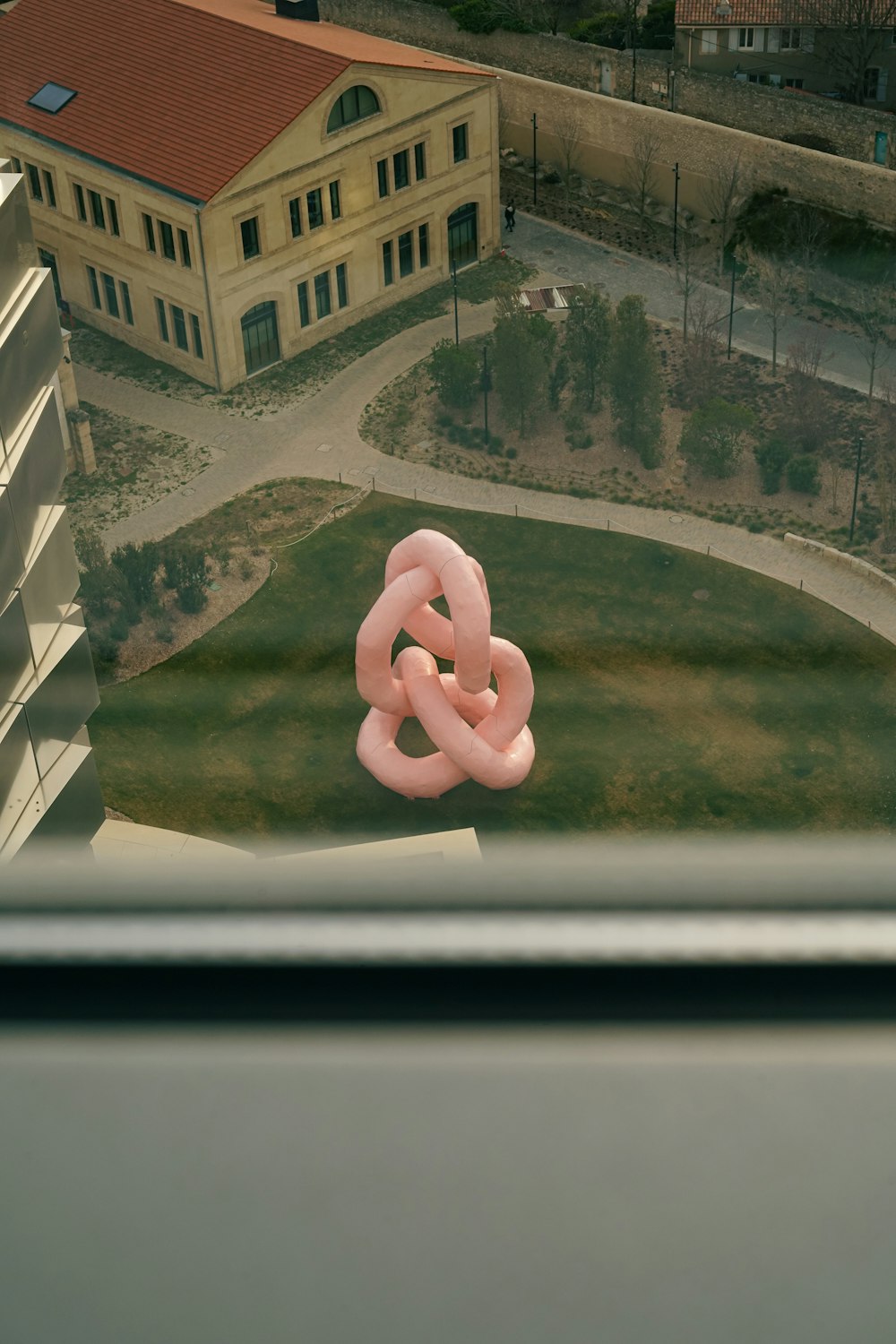 a giant pink inflatable object in front of a building
