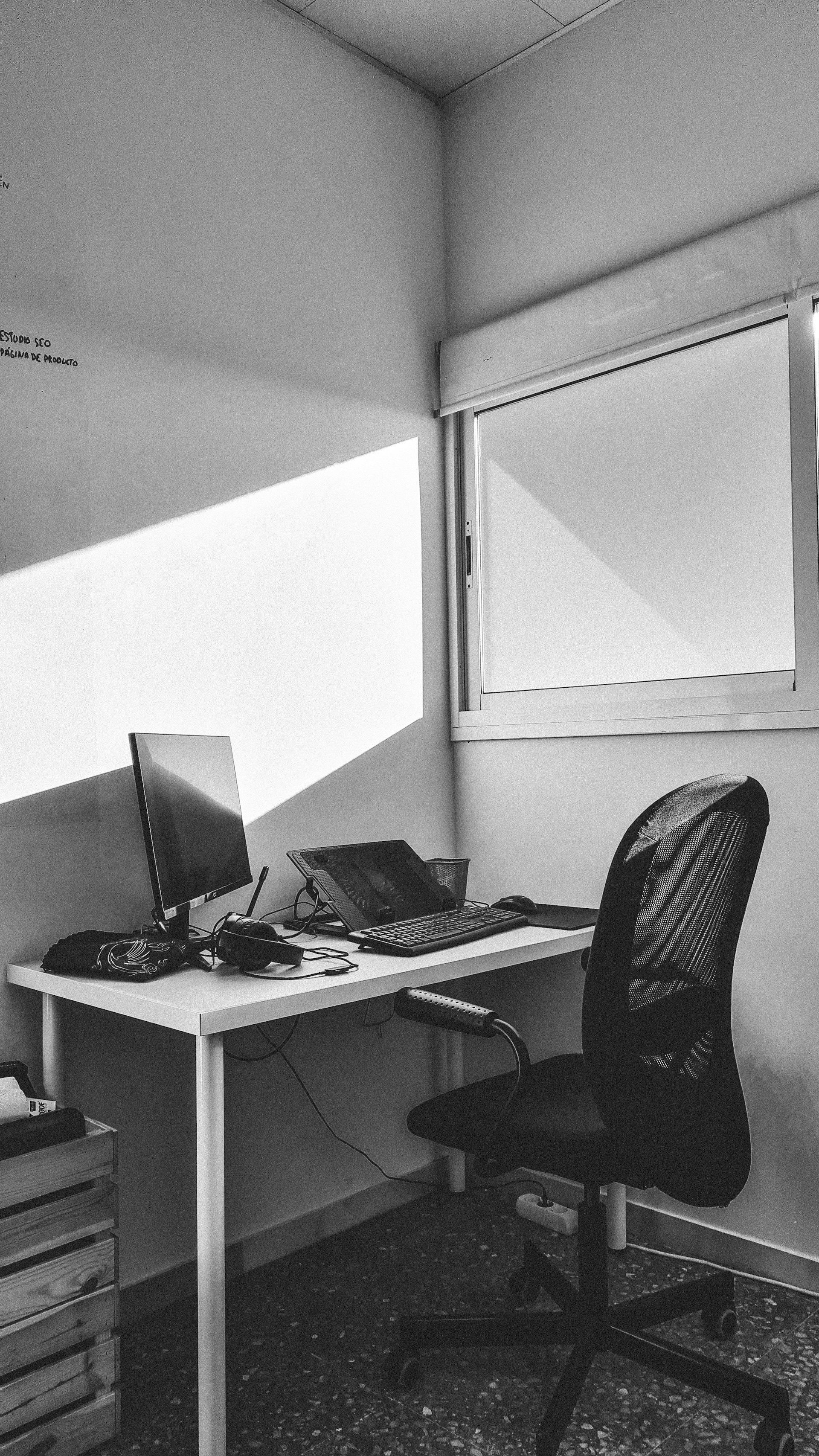 Minimalist office environment featuring a clean desk, a secure server rack in the background, and soft natural lighting.