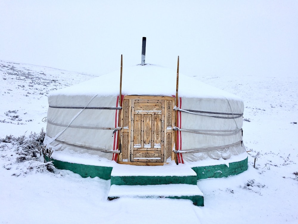 a yurt covered in snow on a snowy day