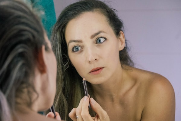 Woman looking at her reflection in a mirror