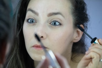 a woman is doing makeup on her face