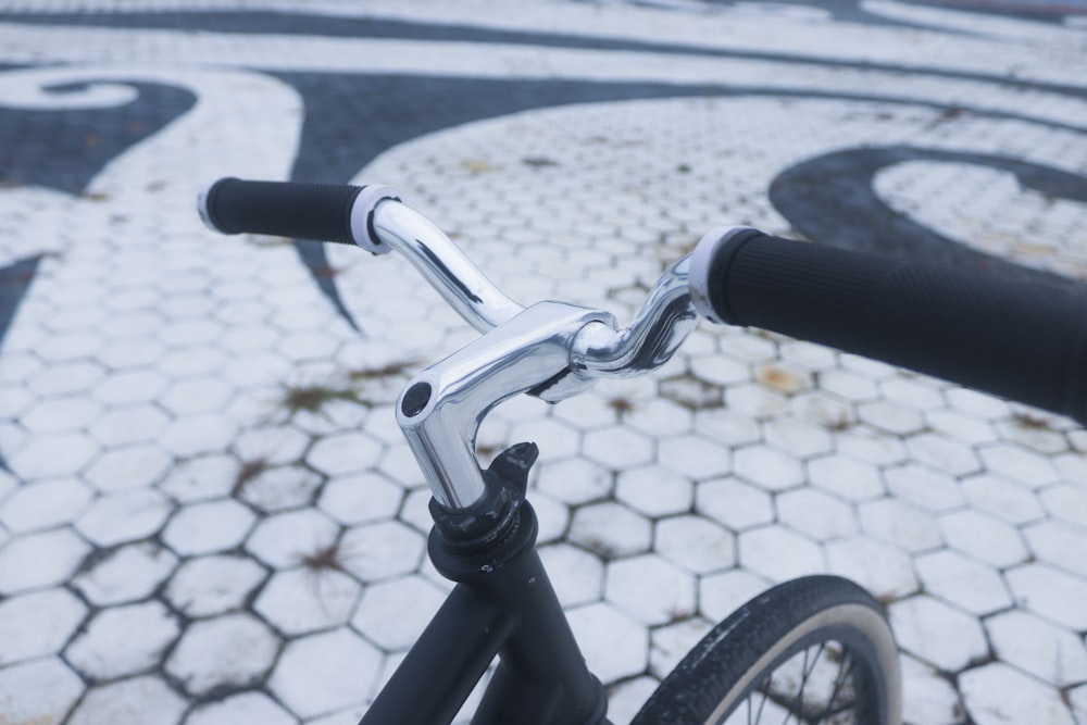 a close up of a bike handle on a cobblestone street