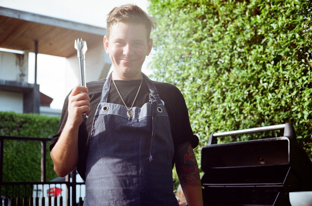 a man in an apron is holding a fork