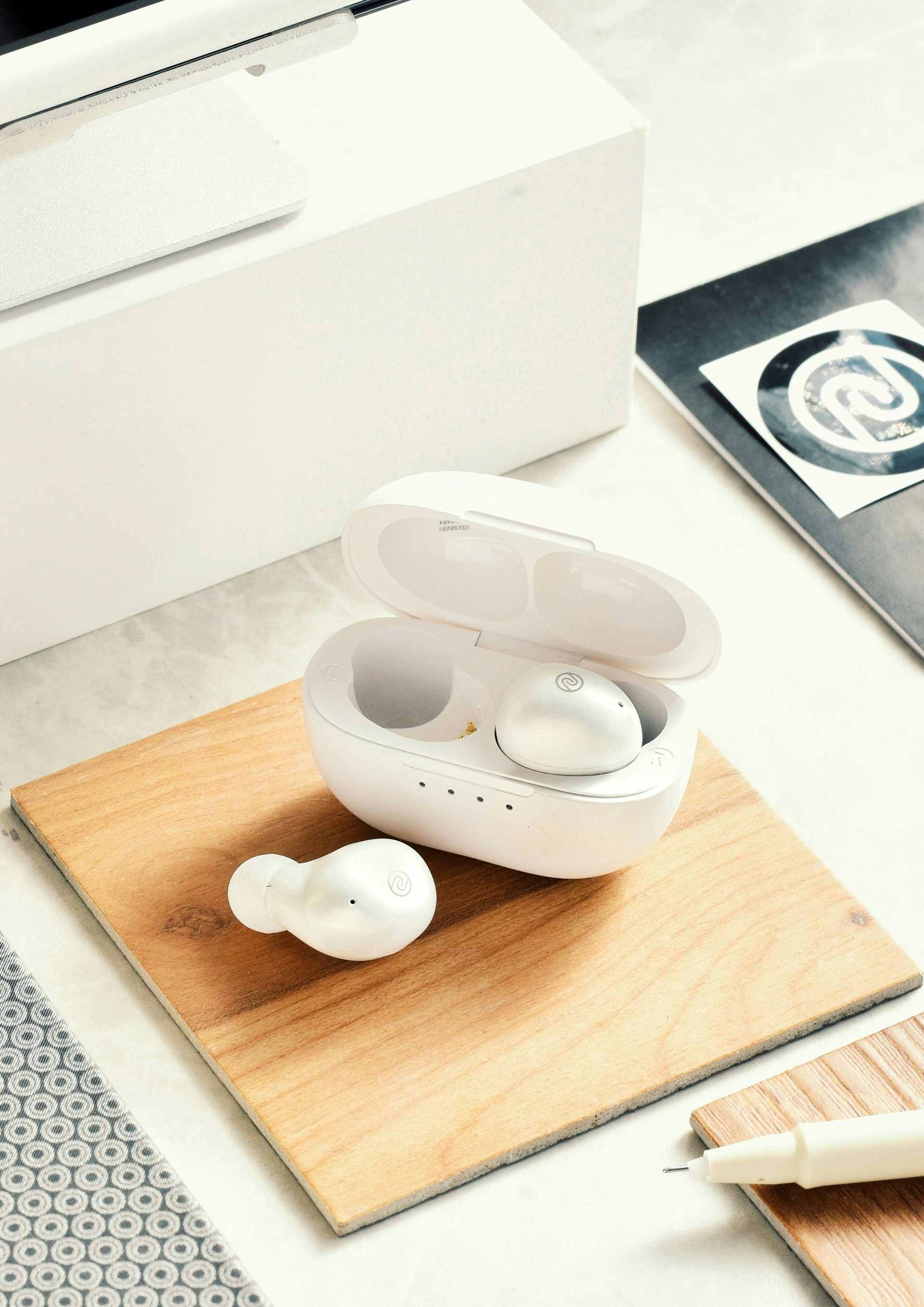 a pair of ear buds sitting on a wooden tray