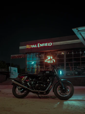 A sleek Royal Enfield motorcycle parked in front of the Majestik Rides dealership on a sunny day.