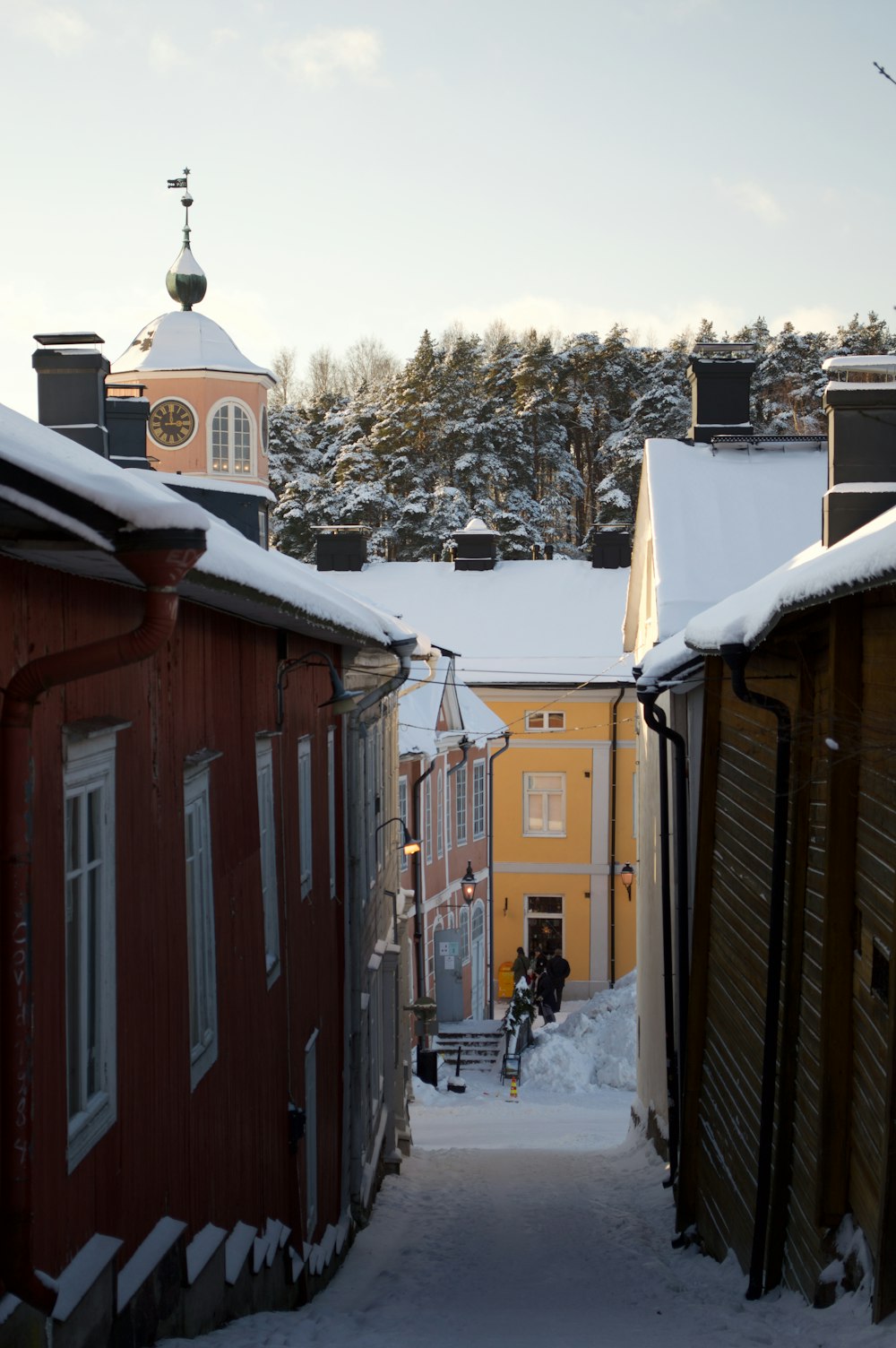 a narrow alley way with snow on the ground