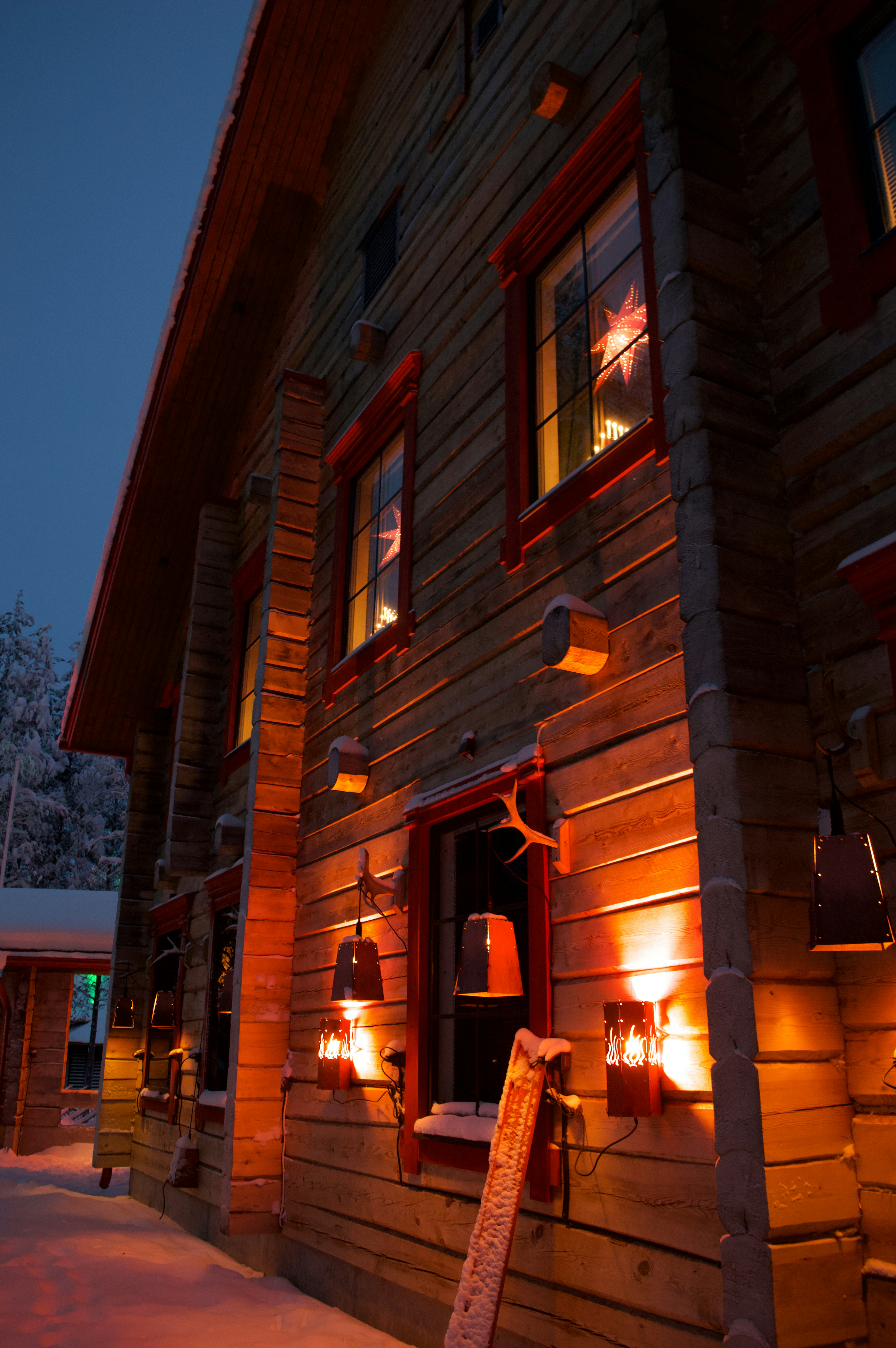 a log cabin with a lit up window at night