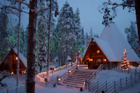 a cabin in the woods is lit up with christmas lights