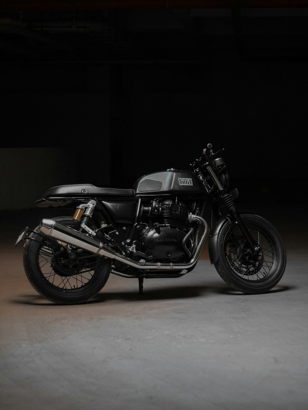 a black motorcycle parked in a dark room