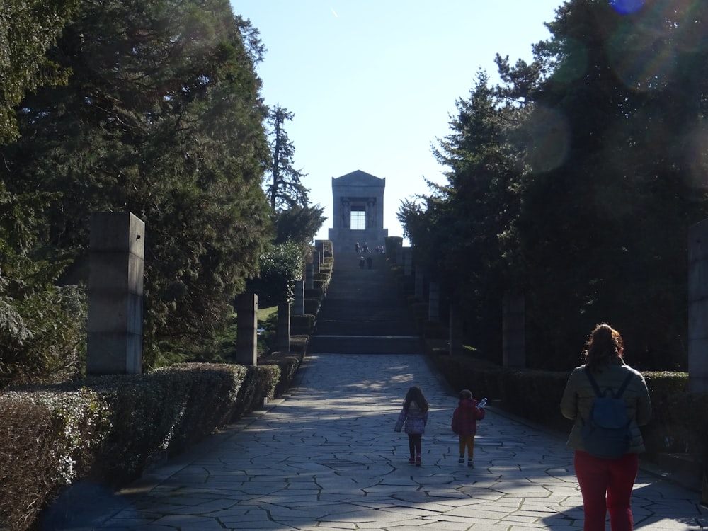 a woman and two children walking down a path