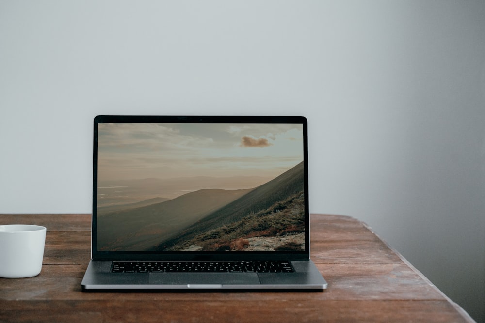 a laptop computer sitting on top of a wooden table