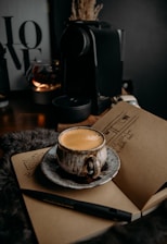 a cup of coffee sitting on top of a book