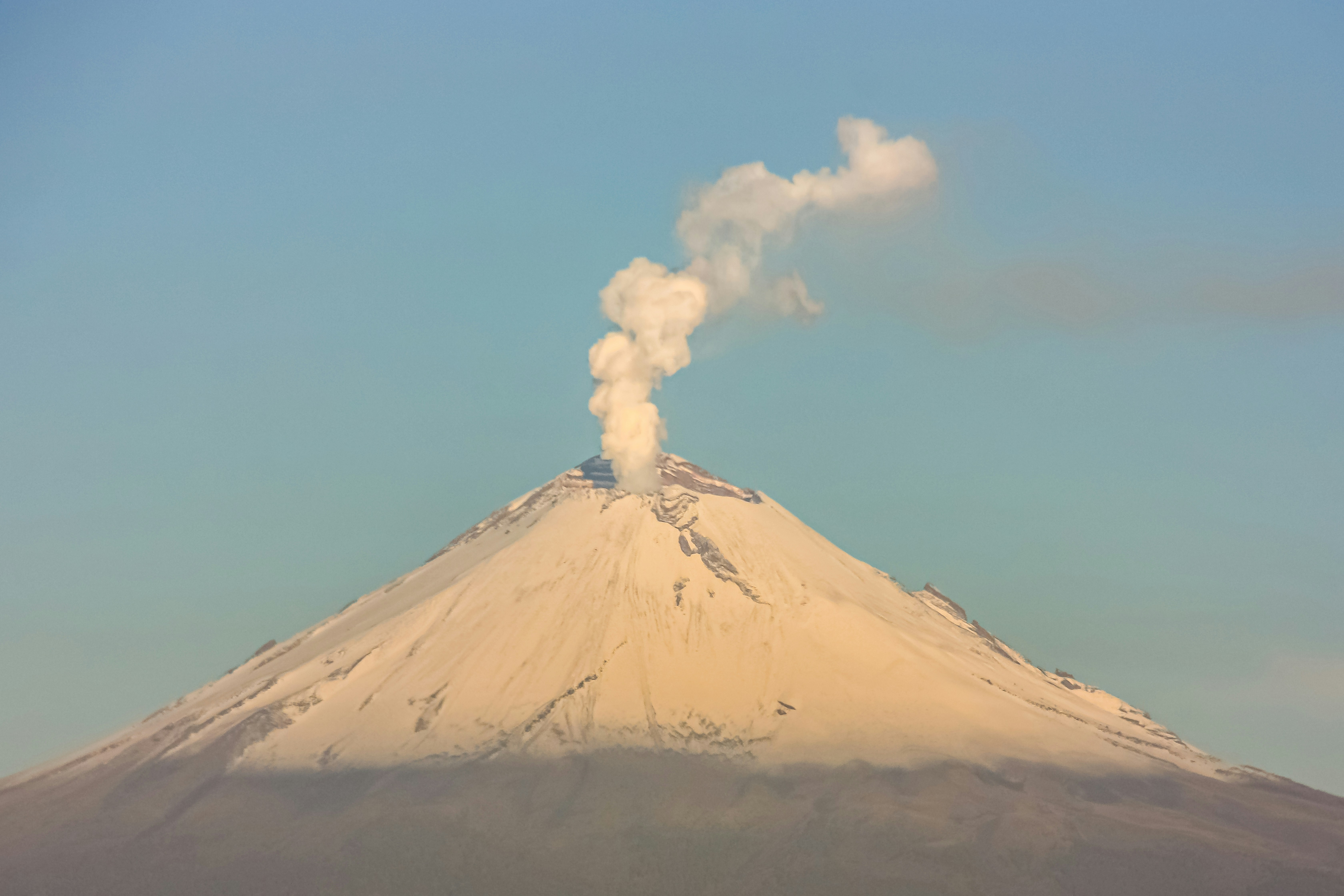 a mountain with a plume of smoke coming out of it