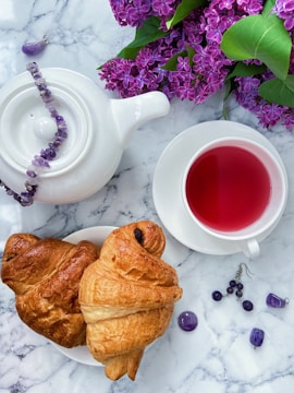 a plate of croissants and a cup of tea on a marble table