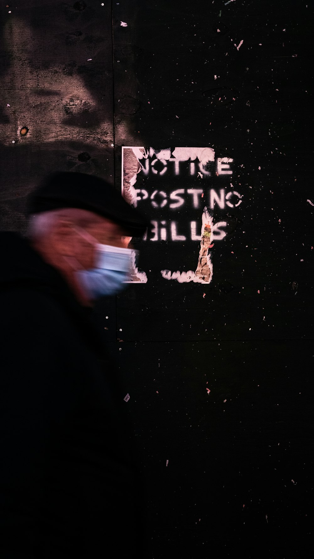 a man wearing a face mask walking down a street