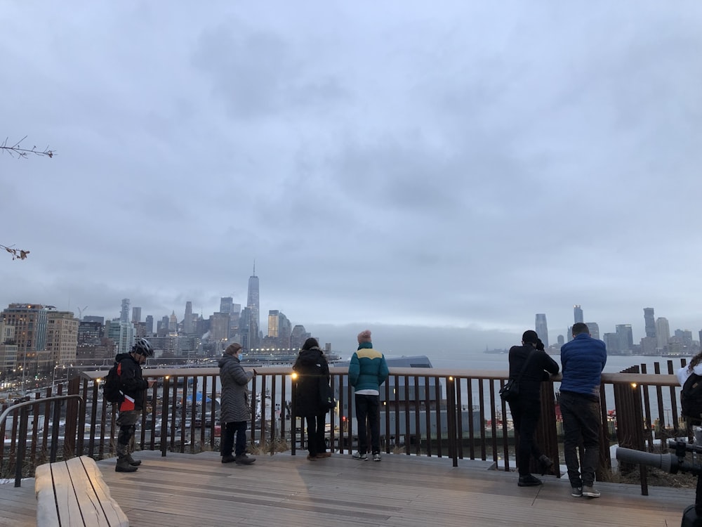 a group of people standing on top of a wooden deck