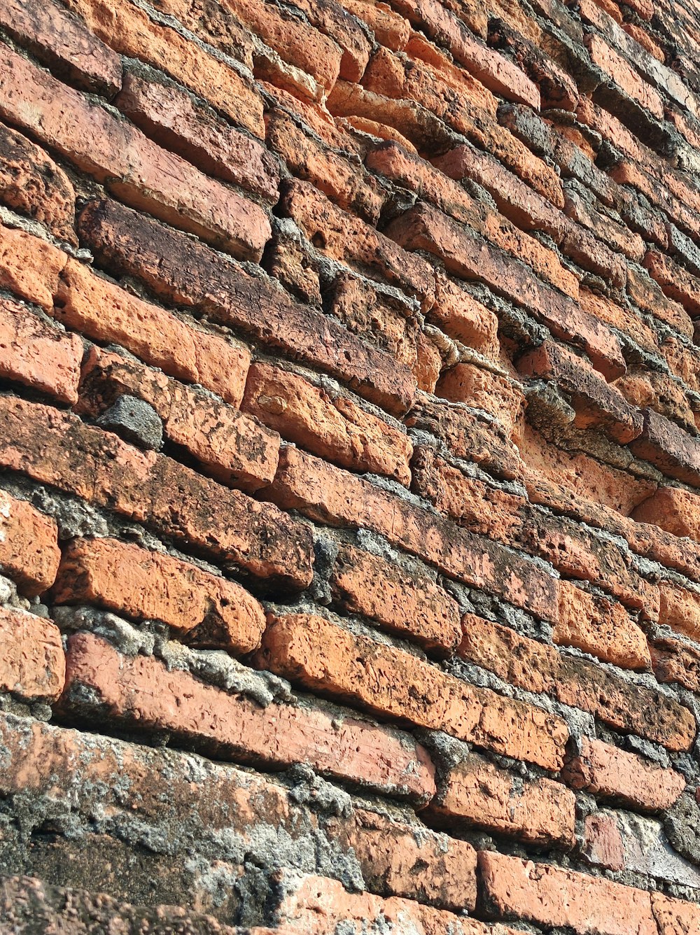 um close up de uma parede de tijolos com um relógio sobre ele