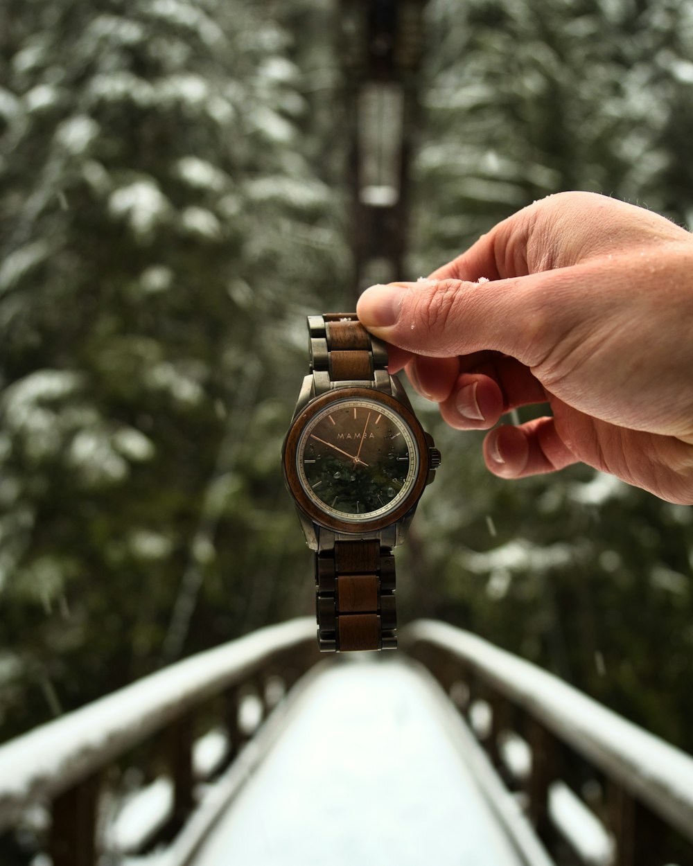 a person holding onto a watch while standing on a bridge