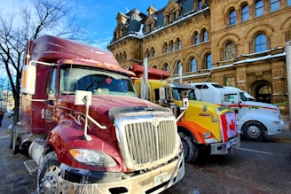 a red semi truck parked next to a yellow semi truck