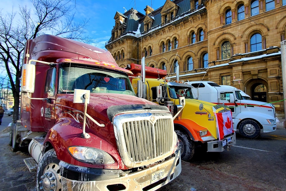 a red semi truck parked next to a yellow semi truck
