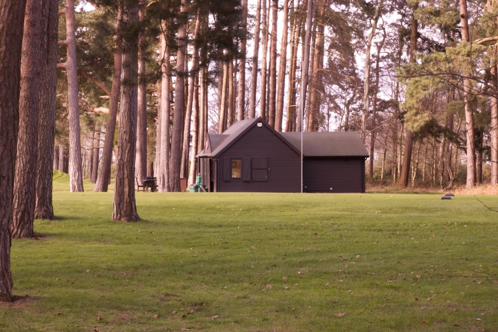 a house in the middle of a field surrounded by trees