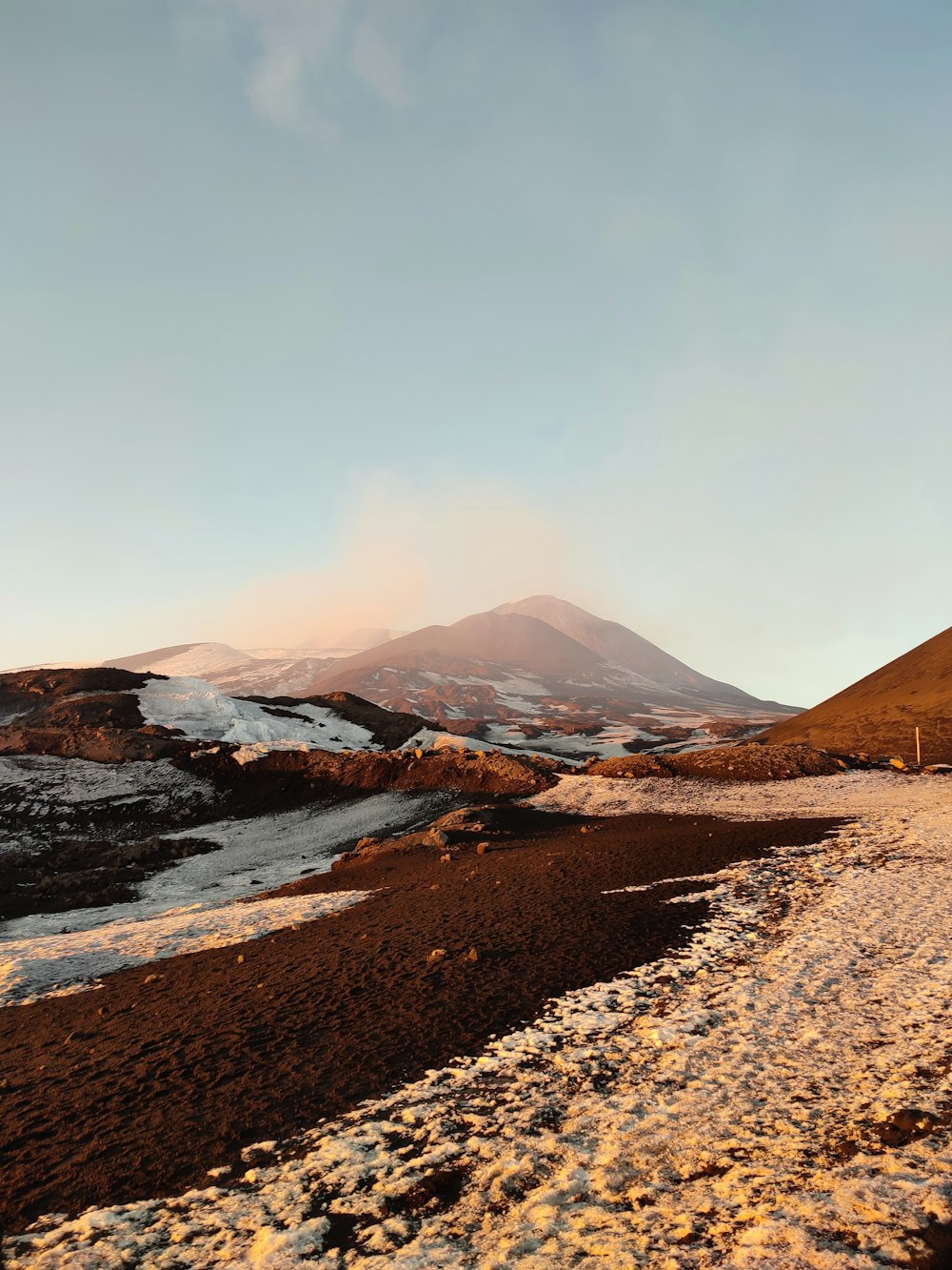 a snow covered field with a mountain in the background