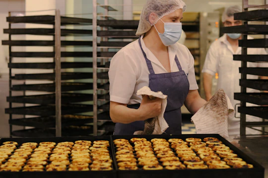 a woman wearing a face mask in a bakery