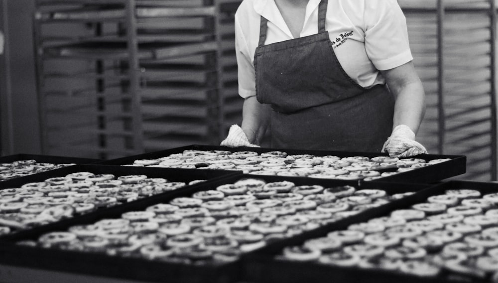 a man standing in front of trays of cupcakes