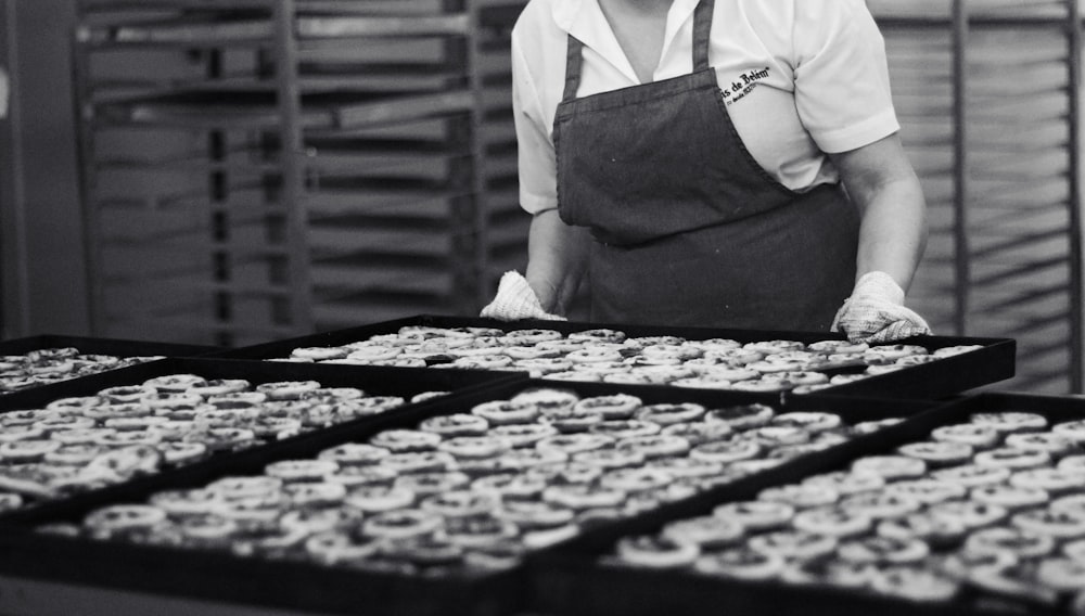 Un homme debout devant des plateaux de cupcakes