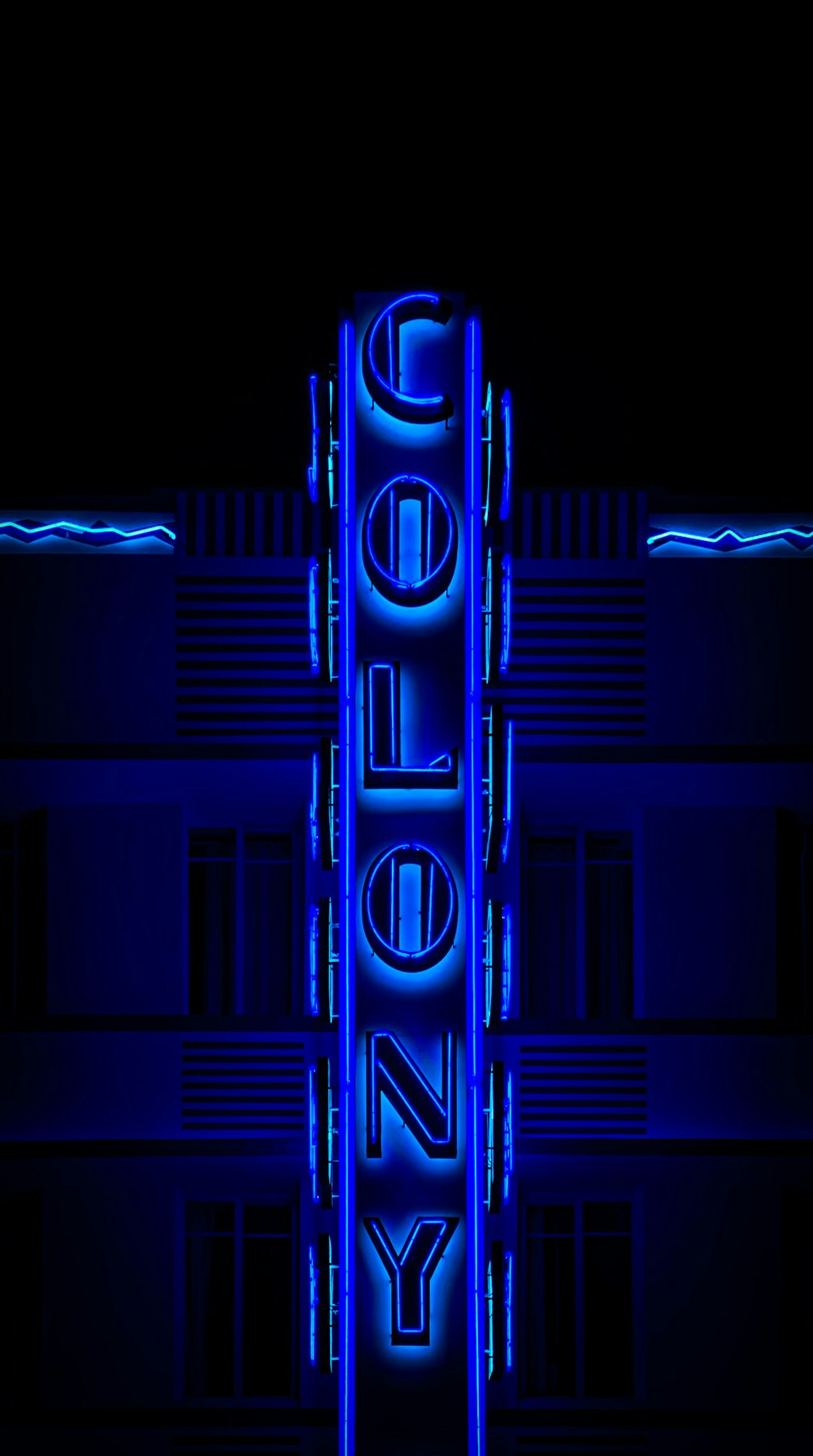 a building with a neon sign on it's side