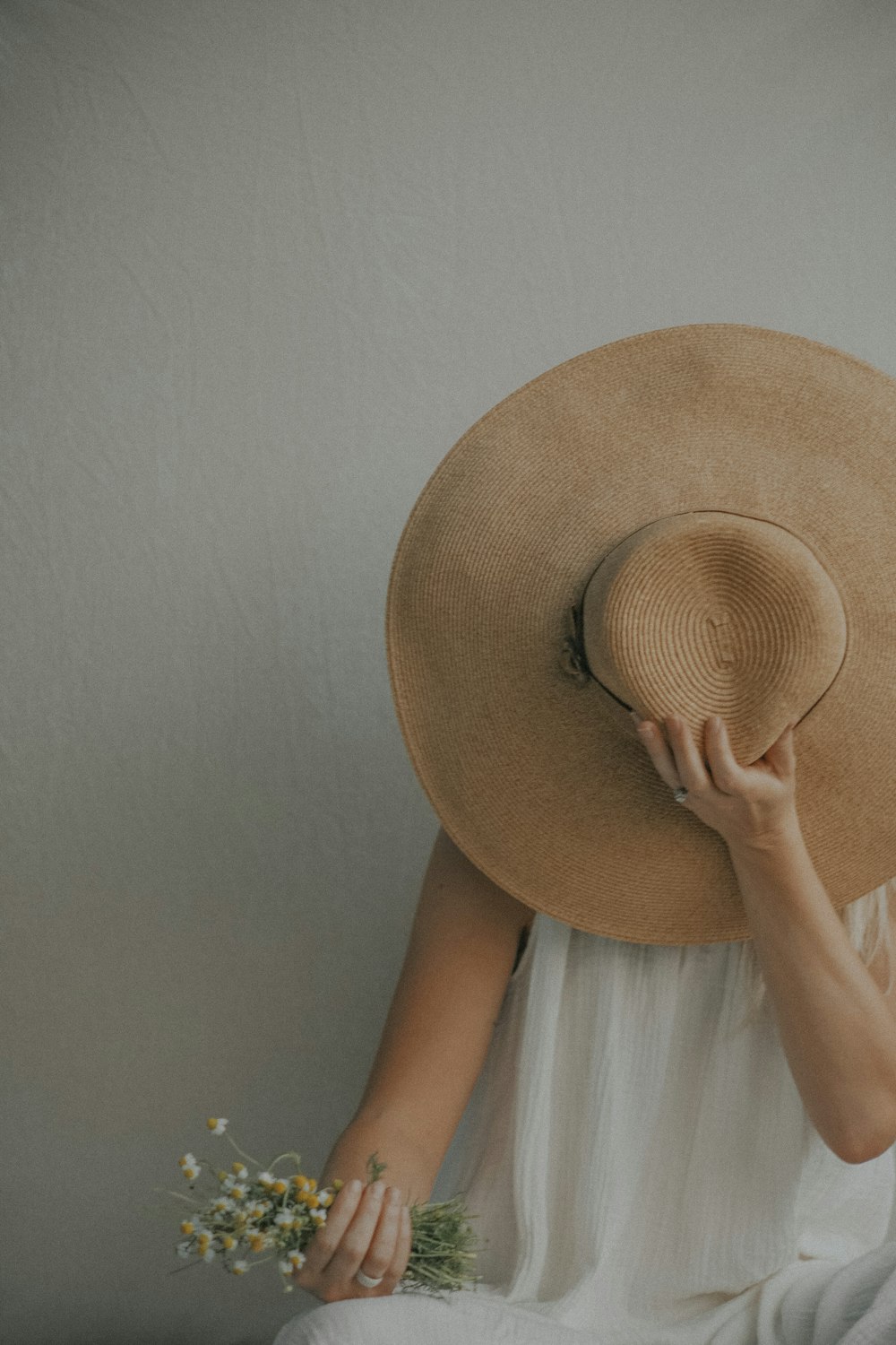 a woman in a white dress and a large hat