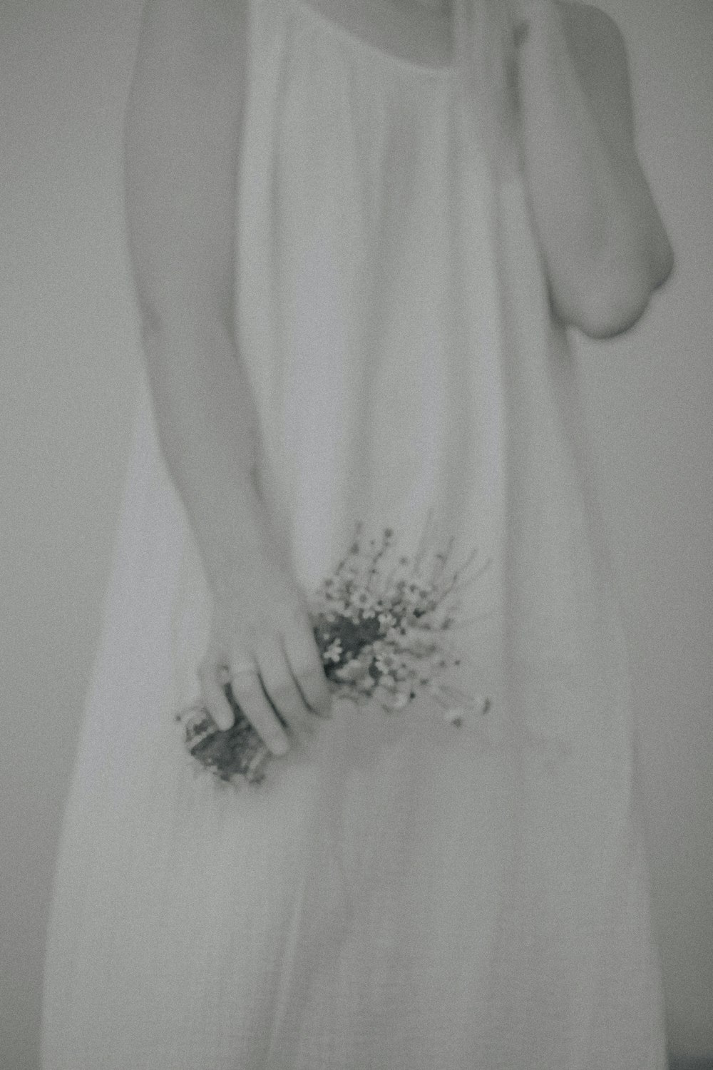 a woman in a white dress holding a bouquet of flowers