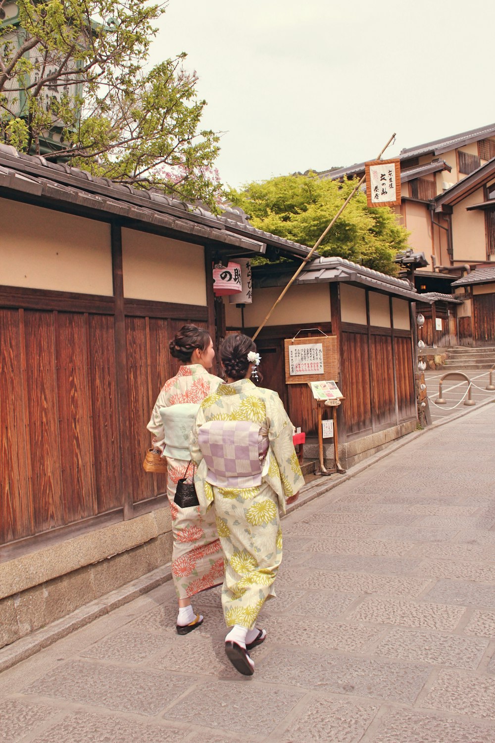 uma mulher em um quimono andando por uma rua