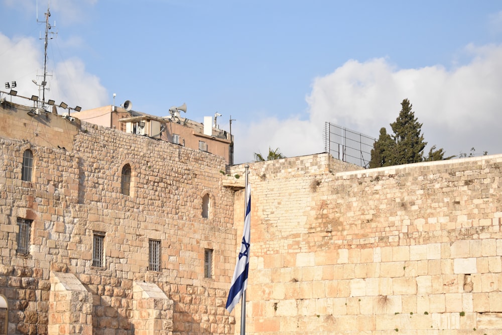 a tall brick building sitting next to a stone wall