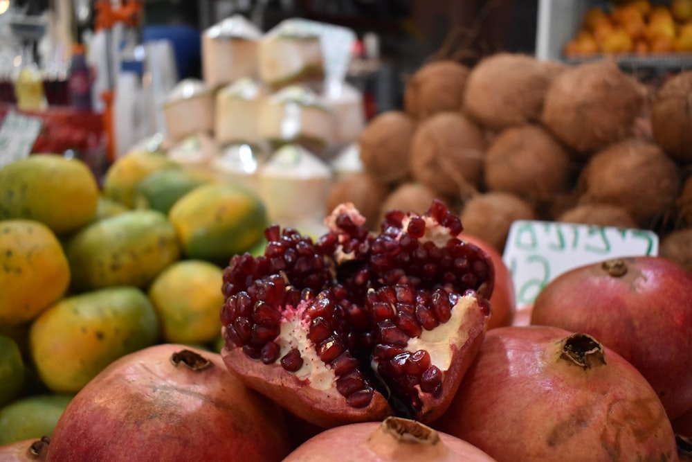 Ein Haufen Granatapfel sitzt auf einem Haufen Obst