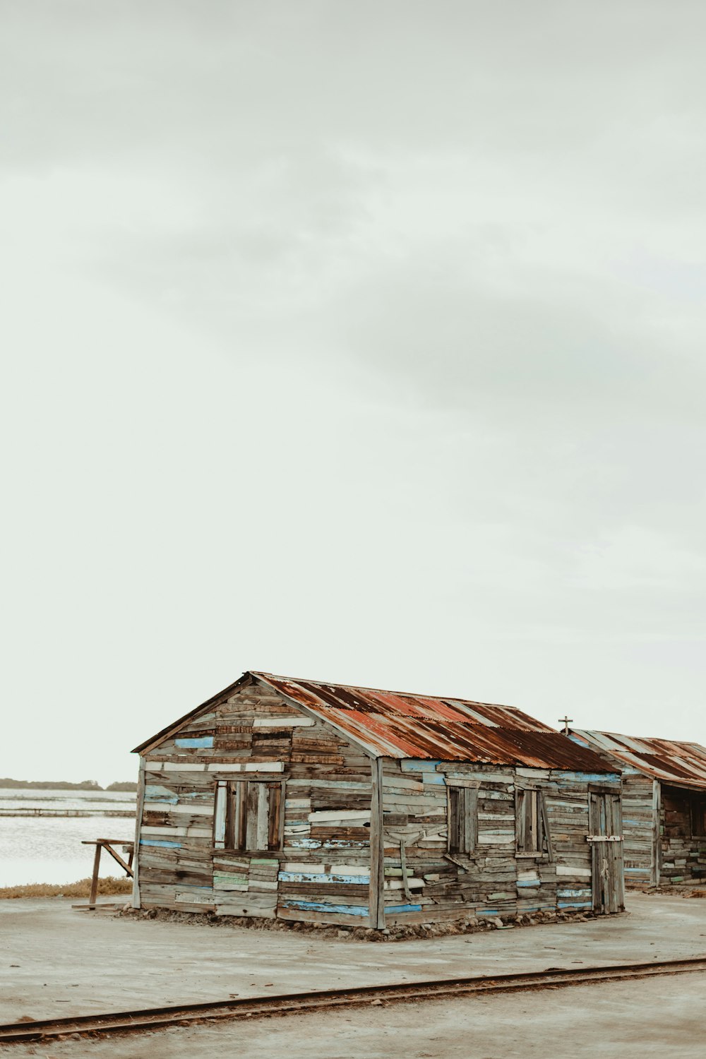 an old wooden shack sitting on the side of a road