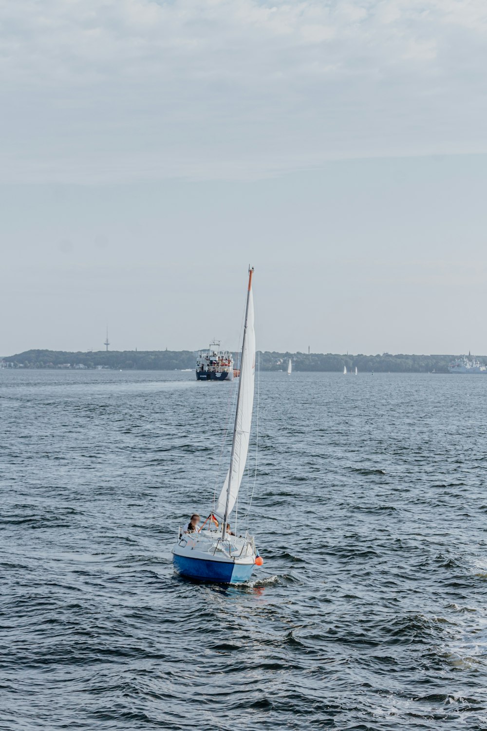 a sailboat sailing in the ocean on a sunny day