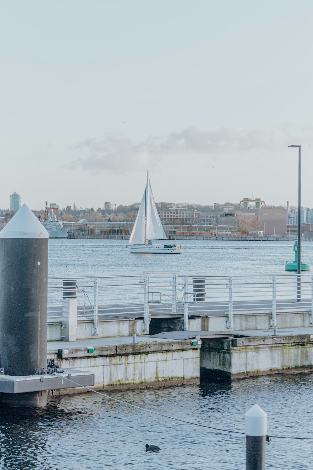 a sailboat in the water near a dock