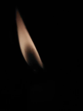 A solemn memorial flame flickering against a dark background symbolizing remembrance.
