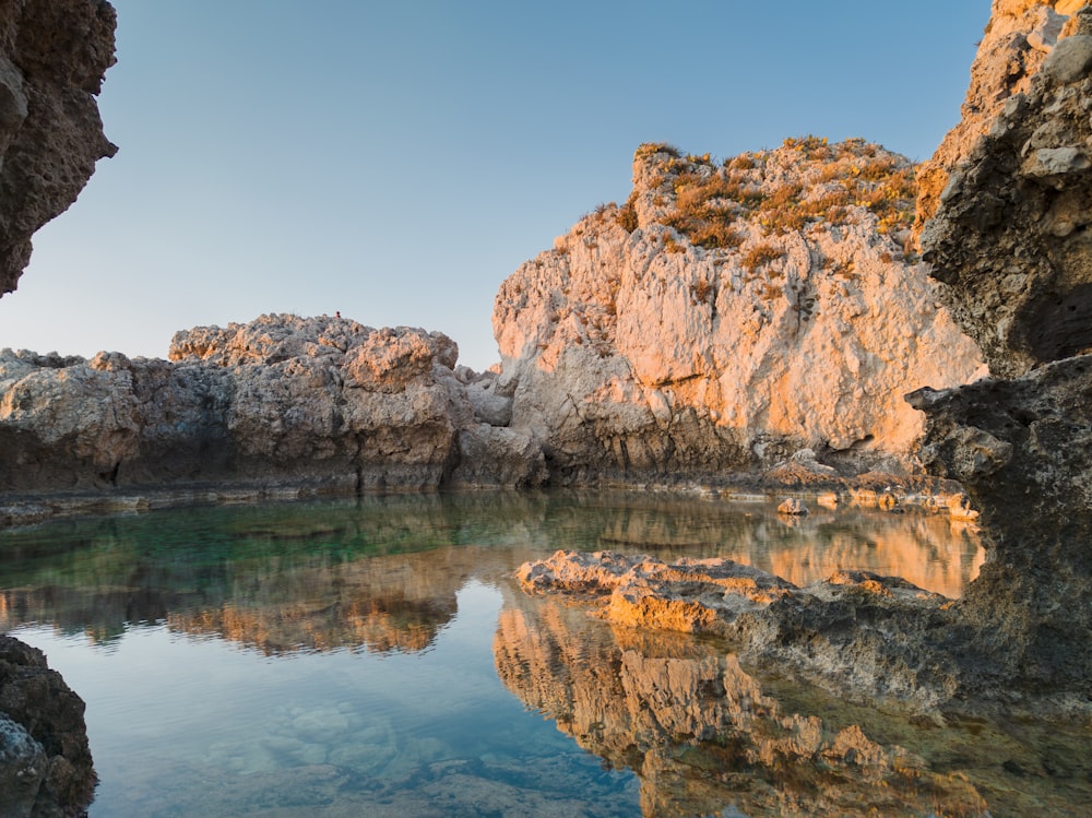 a body of water surrounded by rocky cliffs